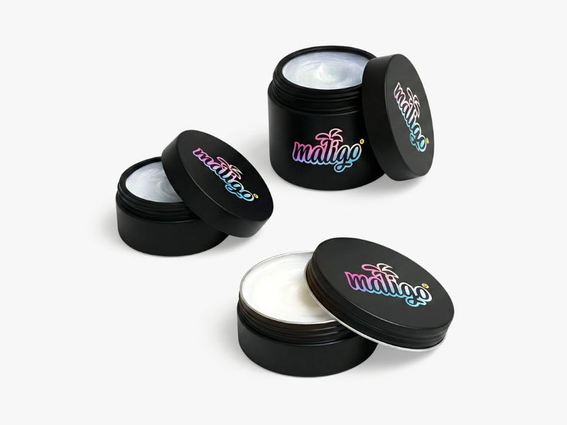 Drei schwarze maligo® Dosen mit buntem Logo, offen und geschlossen, mit weißer Creme